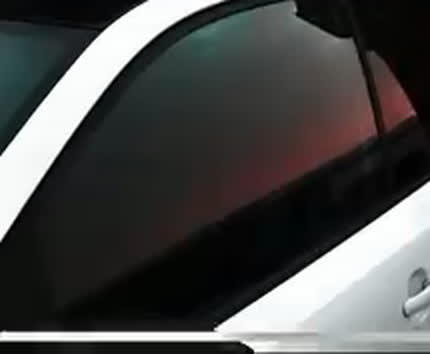 Close-up of dark tinted windows on a white SUV tinted by GRD Creations llc